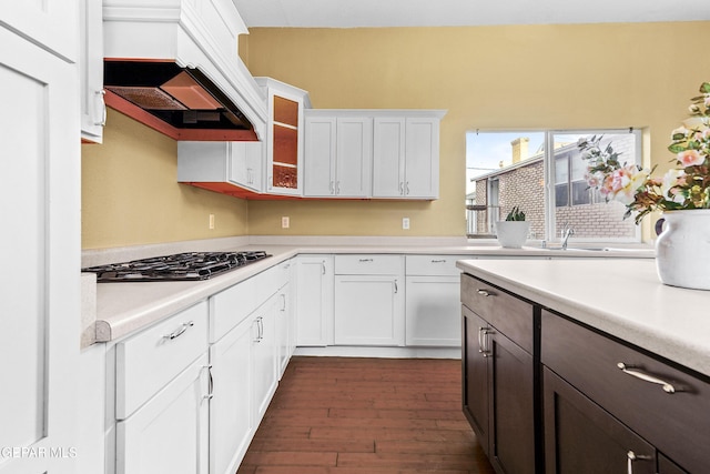 kitchen with sink, stainless steel gas stovetop, dark hardwood / wood-style floors, and white cabinets