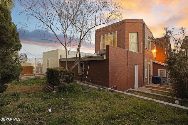 property exterior at dusk with a yard