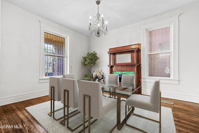 dining space with an inviting chandelier and dark hardwood / wood-style floors