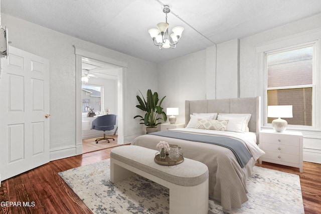 bedroom featuring dark wood-type flooring and an inviting chandelier