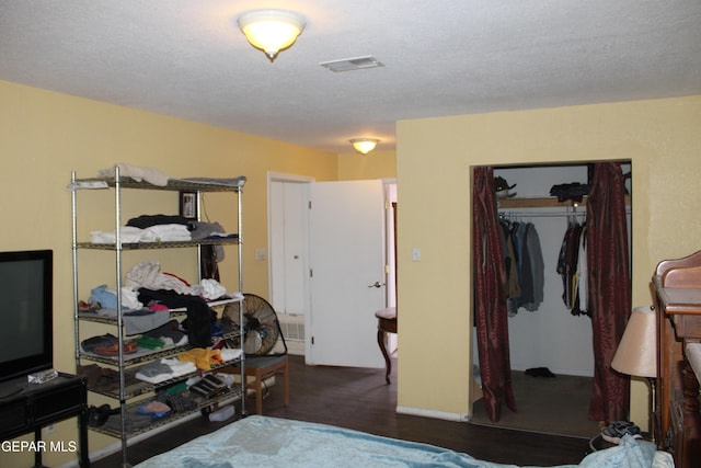 bedroom featuring dark wood-type flooring, a closet, and a textured ceiling