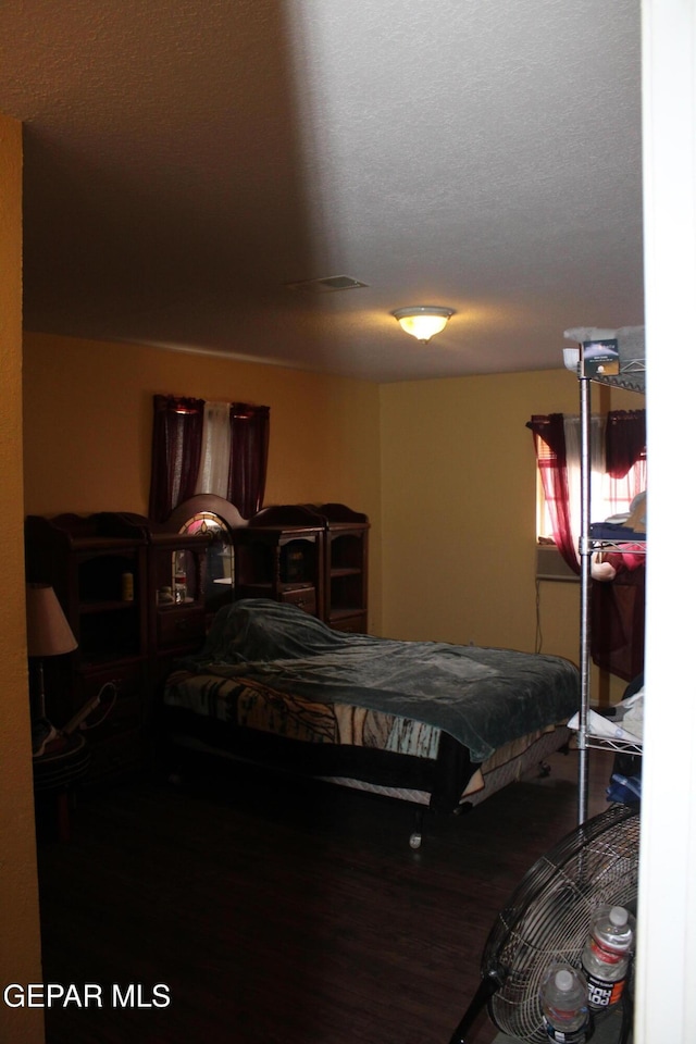 bedroom featuring wood-type flooring and a textured ceiling