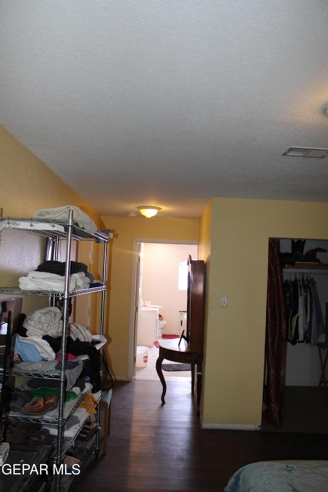 bedroom with hardwood / wood-style flooring, a closet, and a textured ceiling