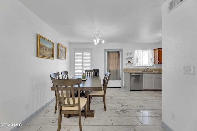 dining area featuring plenty of natural light, sink, and a notable chandelier