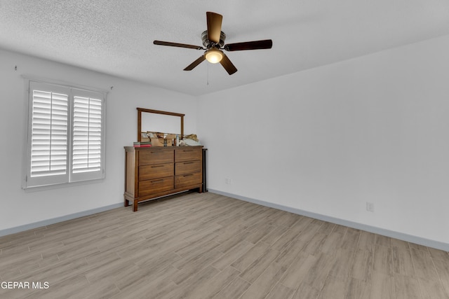 bedroom featuring ceiling fan, light hardwood / wood-style floors, and a textured ceiling