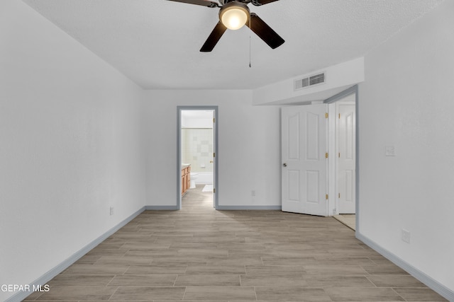 unfurnished room with ceiling fan, light hardwood / wood-style floors, and a textured ceiling