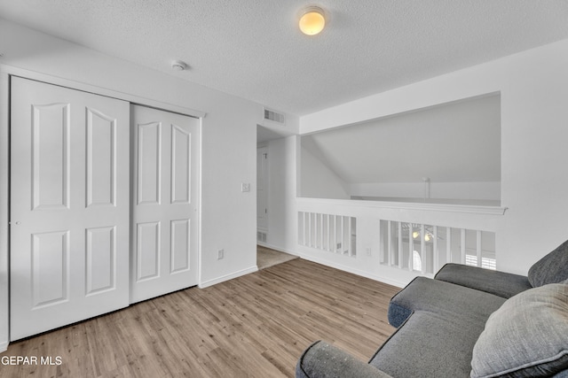 sitting room featuring light hardwood / wood-style flooring and a textured ceiling