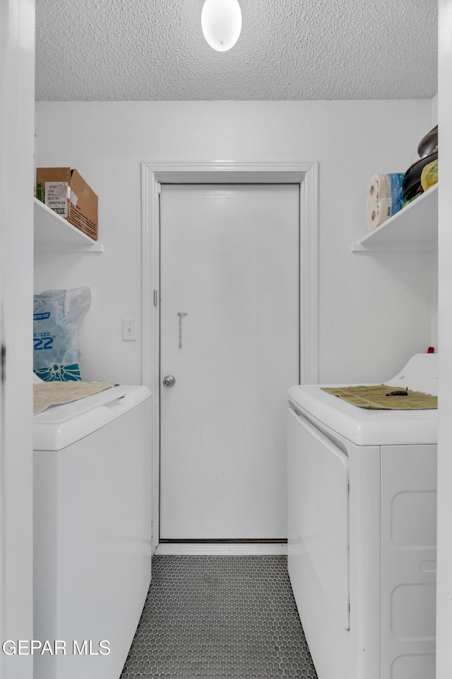 washroom with separate washer and dryer and a textured ceiling