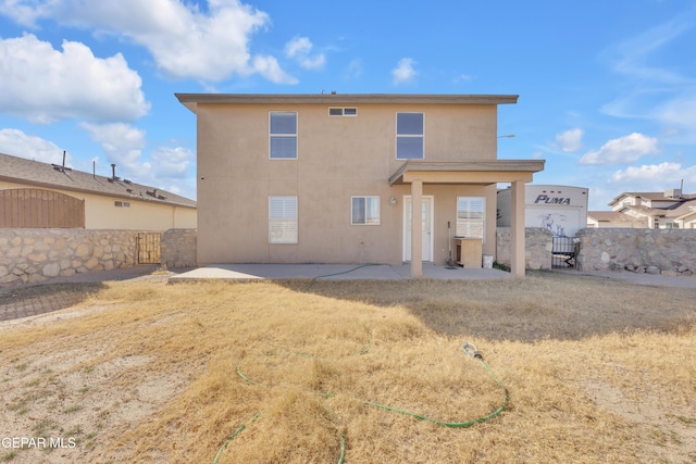 back of house with a patio and a yard