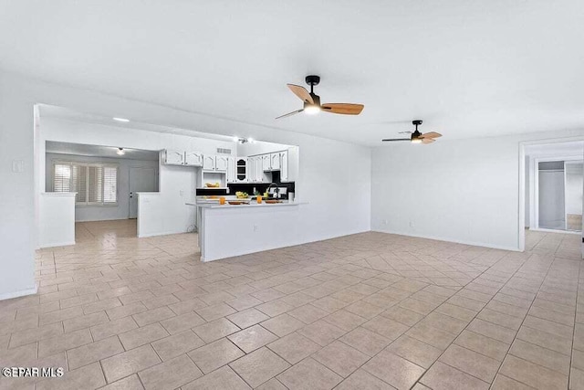 unfurnished living room with ceiling fan