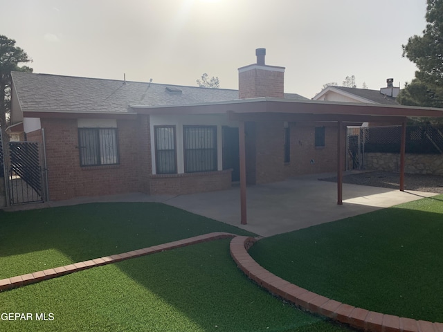 back of house with a lawn and a carport