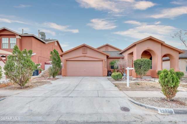 view of front of property with a garage, concrete driveway, and stucco siding