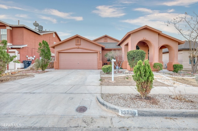 view of front of home with a garage, driveway, and stucco siding