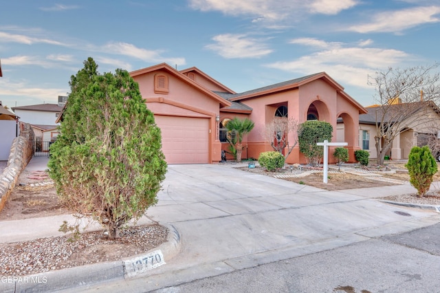 view of front of house with driveway, an attached garage, and stucco siding