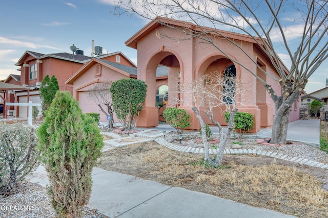 view of front of property featuring an attached garage and stucco siding