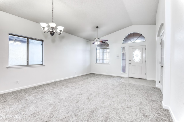 entrance foyer with light carpet, vaulted ceiling, ceiling fan with notable chandelier, and baseboards