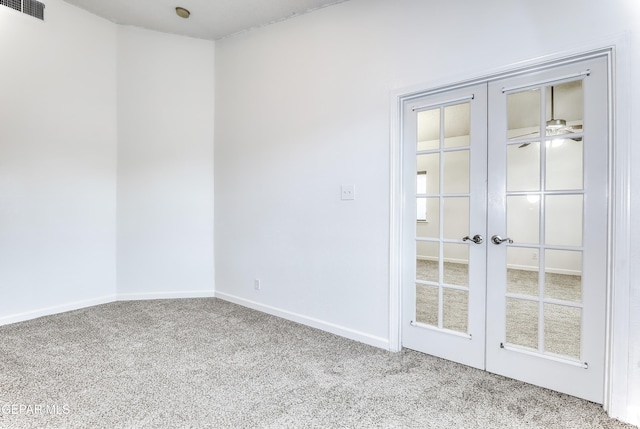 unfurnished room with light carpet, french doors, visible vents, and baseboards