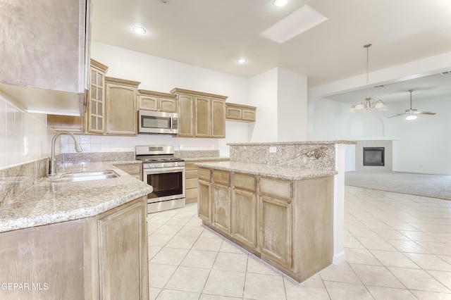 kitchen featuring light tile patterned floors, a sink, appliances with stainless steel finishes, glass insert cabinets, and pendant lighting