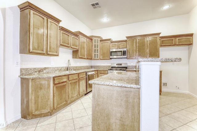 kitchen featuring stainless steel appliances, a sink, visible vents, brown cabinets, and glass insert cabinets