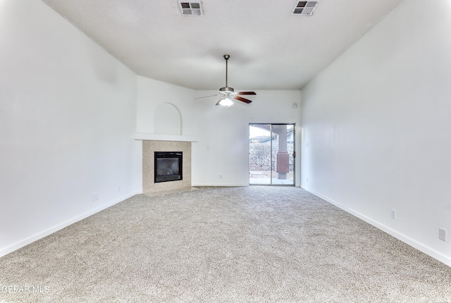 unfurnished living room featuring a tile fireplace, carpet flooring, visible vents, and a ceiling fan