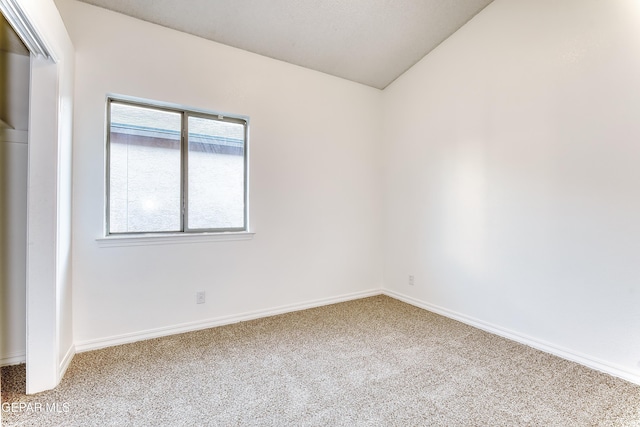 unfurnished room with carpet, lofted ceiling, and baseboards