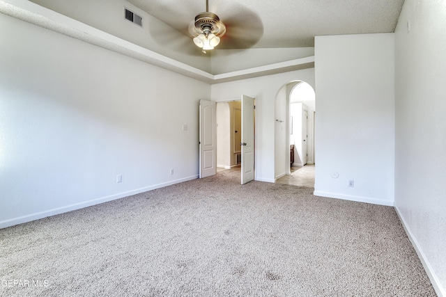 unfurnished bedroom with arched walkways, visible vents, a ceiling fan, light carpet, and baseboards