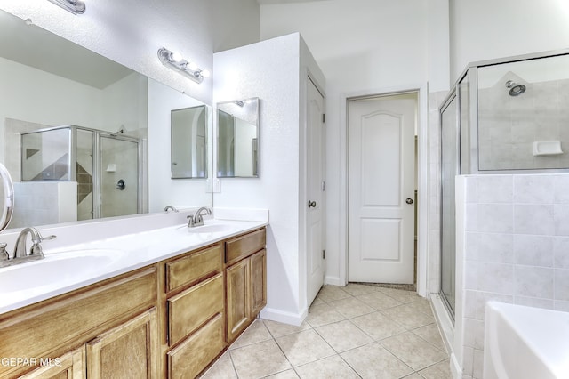 full bath with double vanity, a stall shower, tile patterned flooring, and a sink