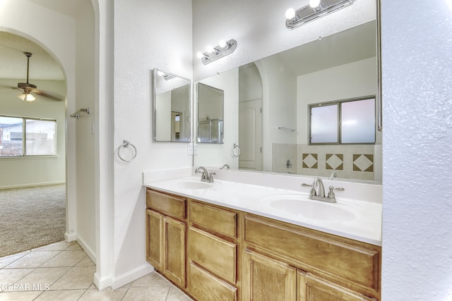 bathroom featuring ceiling fan, double vanity, a sink, and tile patterned floors