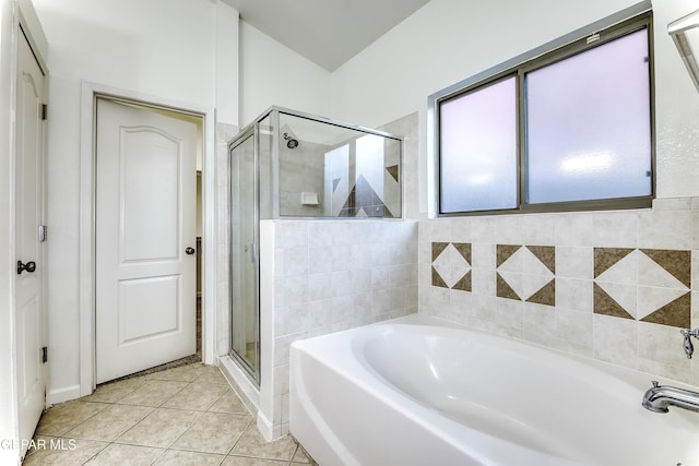 bathroom featuring a garden tub, tile patterned flooring, and a shower stall