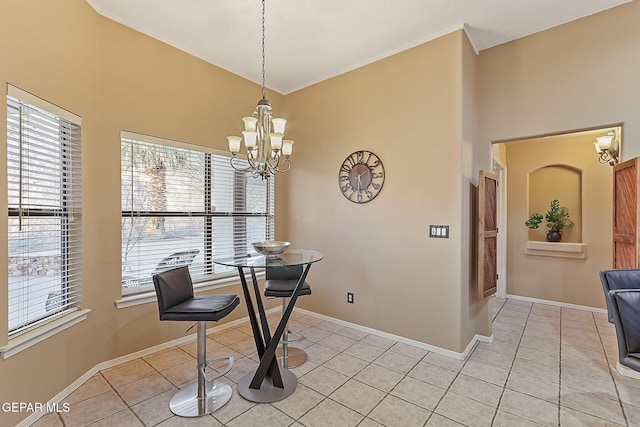 dining room featuring light tile patterned flooring, ornamental molding, and an inviting chandelier