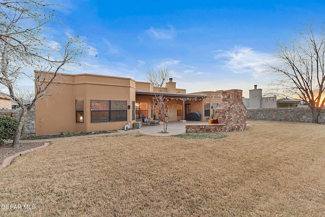 rear view of house featuring a yard and a patio