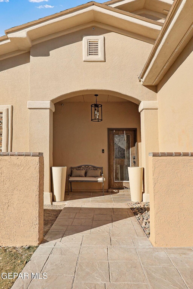 view of exterior entry featuring a patio area