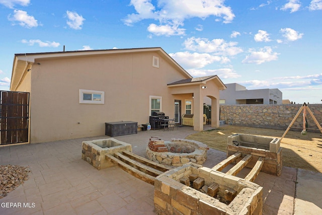 rear view of house featuring a patio and a fire pit