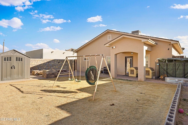 view of play area with central AC, a patio area, and a storage unit