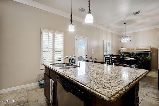 kitchen with sink, light stone counters, decorative light fixtures, dishwasher, and an island with sink