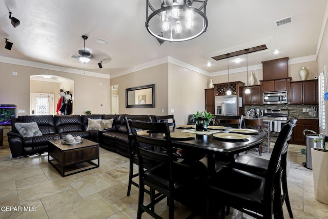 dining space with crown molding and ceiling fan