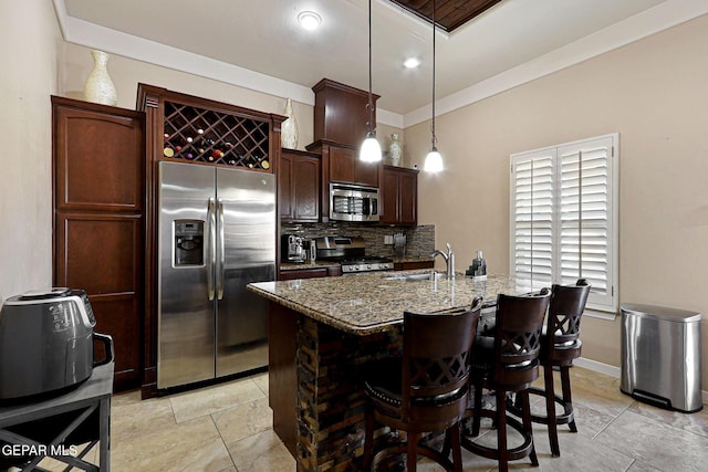 kitchen with dark brown cabinetry, sink, stone countertops, pendant lighting, and stainless steel appliances