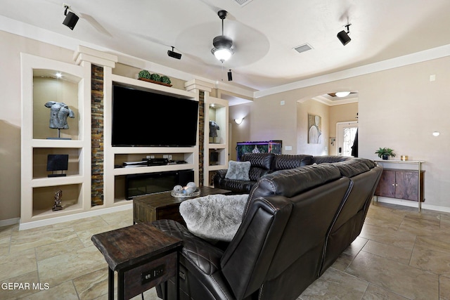 living room featuring built in shelves, ceiling fan, ornamental molding, and track lighting