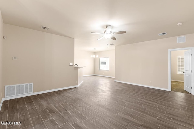 unfurnished room featuring ceiling fan with notable chandelier and dark wood-type flooring