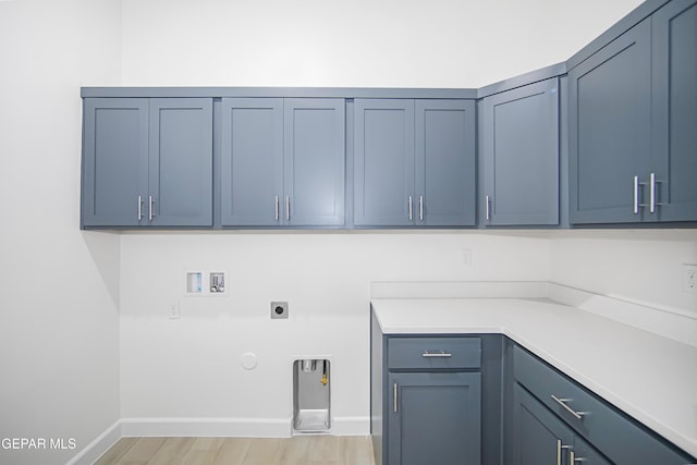 clothes washing area featuring gas dryer hookup, electric dryer hookup, cabinets, washer hookup, and light hardwood / wood-style floors