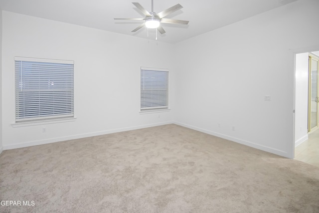 spare room with light colored carpet and ceiling fan