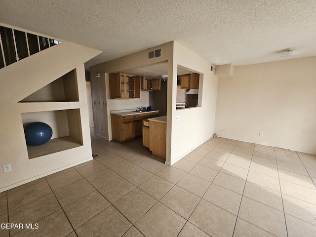 unfurnished living room featuring a textured ceiling and light tile patterned floors