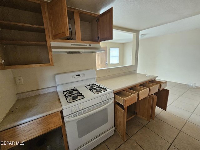 kitchen with light tile patterned floors and white gas range oven