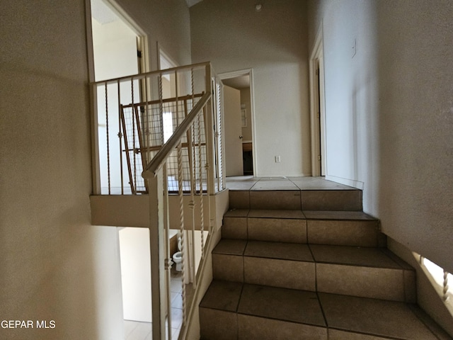 stairway featuring tile patterned flooring