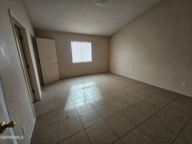 unfurnished room with light tile patterned floors and a textured ceiling