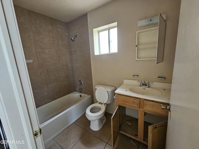 full bathroom featuring tiled shower / bath, vanity, toilet, and tile patterned flooring