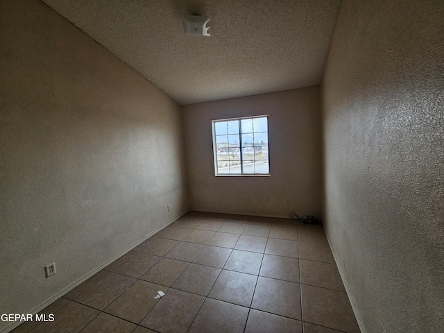 empty room featuring light tile patterned flooring and a textured ceiling