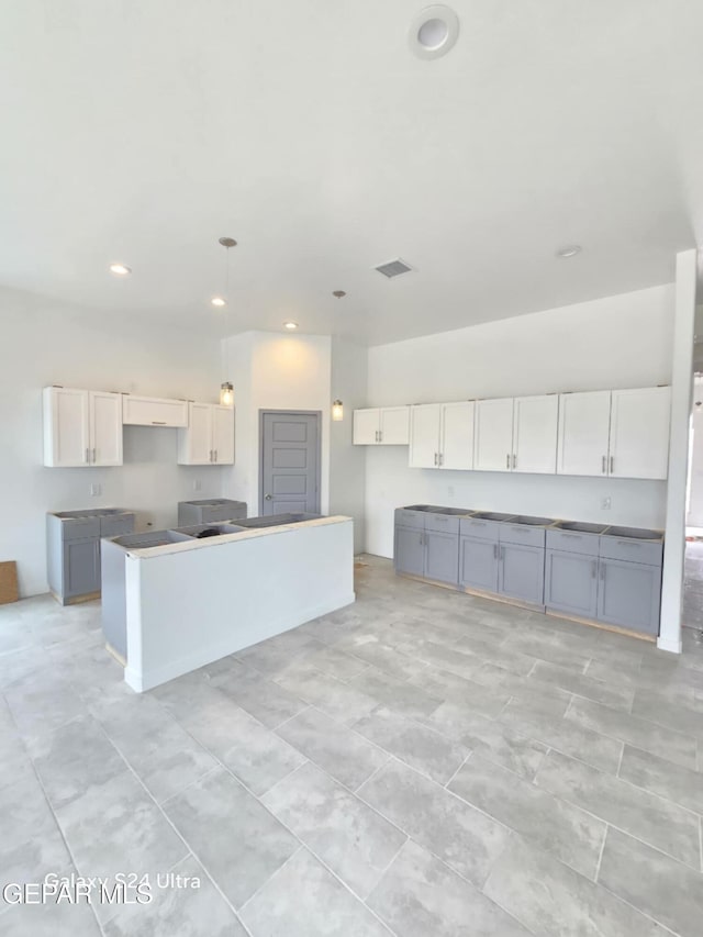 kitchen with white cabinetry, gray cabinets, and a kitchen island