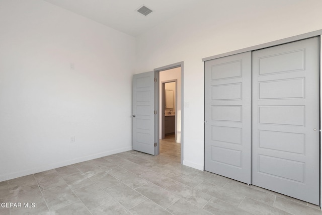 unfurnished bedroom featuring a closet, visible vents, and baseboards