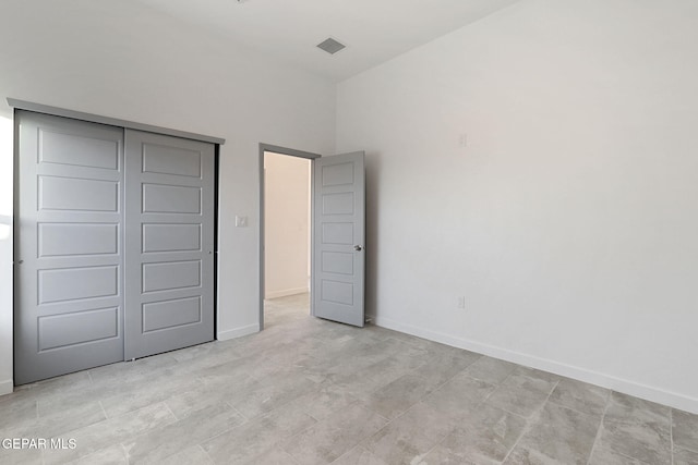 unfurnished bedroom with a closet, visible vents, and baseboards